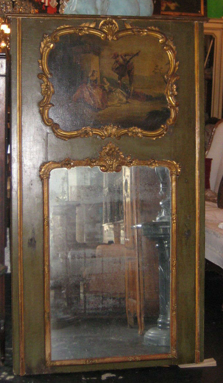Louis XV painted and parcel gilt trumeau mirror, the molded cornice over a Watteau'esque painting above the original mirror plate all within a green painted and parcel gilt rectangular frame, the verso with construction elements typical of 18th