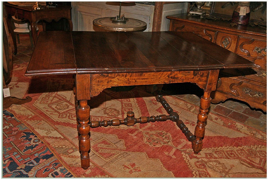 18th century walnut French Louis XIII style table with drop sides from bastide le trentin. Originally used between a sofa and a fireplace.
Measures: H 28" l (leaves down) - 3' l (leaves up) - 4' 5½", W 35¾".