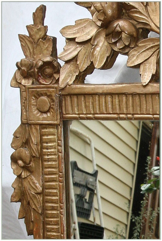 18th century transitional Louis XV/Louis XVI carved mirror from a chateau with intricate floral carving on frame and cartouche on top and column inside, circa 1775.

Measures: H 43", W 26".