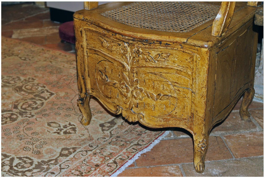 Early 18th century transitional Regency Louis XV painted commode (potty chair)
with caned back and seat. The chair is adored with hand-carved flowers and acanthus leaves.