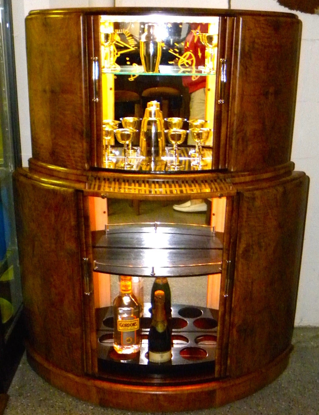 1930s Art Deco English demilune bar can fit all your needs. It smartly and securely holds bottles, glasses, cocktail implements and accessories. It offers a discreet then fun- to-pull-out mixing shelf. It boasts a gorgeous walnut cabinet with