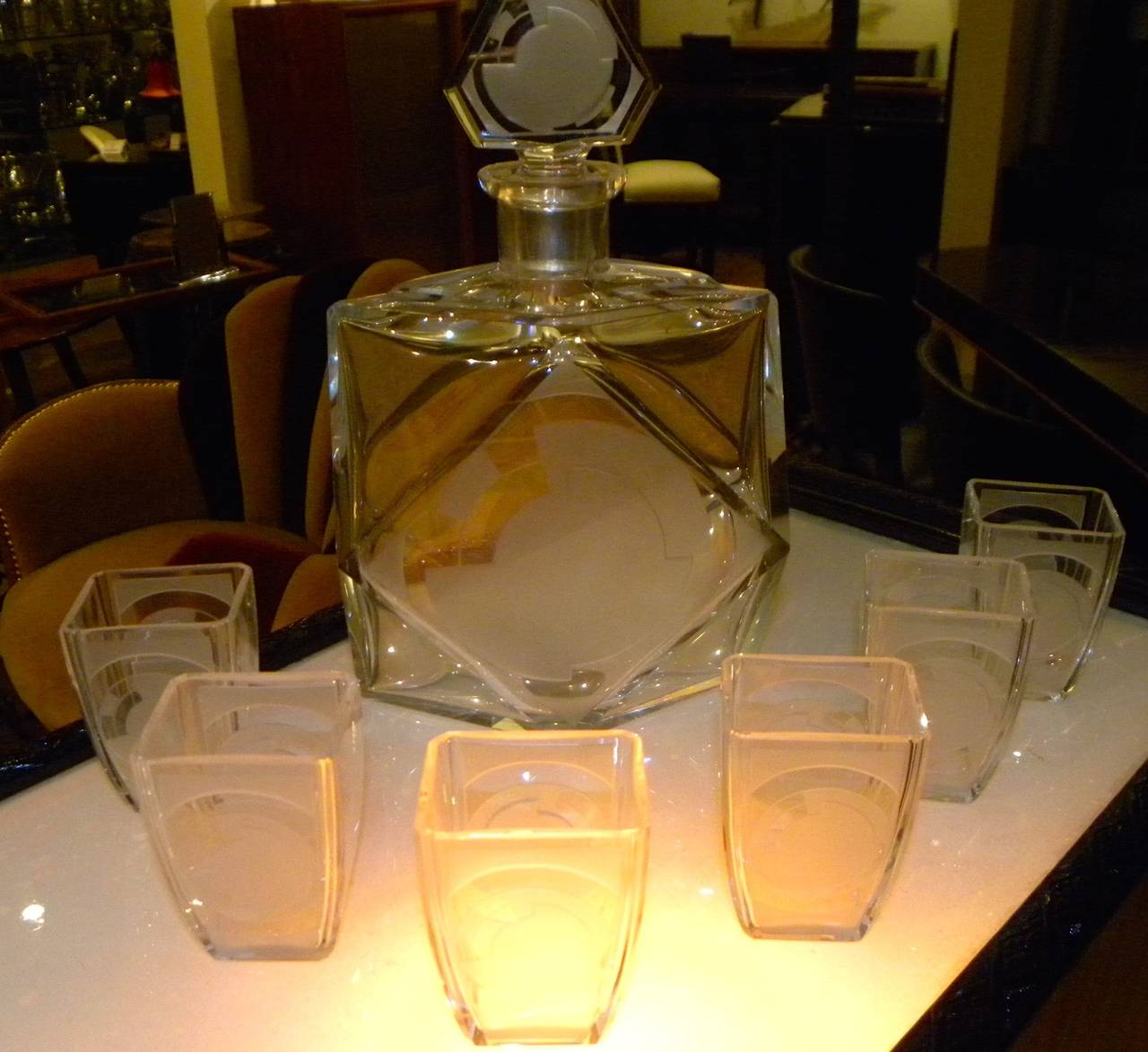 A most unusual Art Deco decanter and six glasses by Baccarat in perfect condition and ready for toasting! The drinking cups have a nice feel, size and weight. The frosted and etched design is geometric and stylish. The faceted sides of the decanter