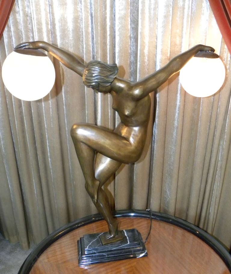 Stunning and striking Art Deco statue lamp of woman holding two globes in crackled glass finish.  Classic Art Deco pose and in a very engaging ballet stance.  This is a monumental  piece,  approximately 33
