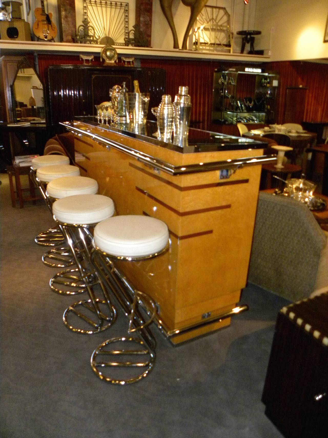 This Parisian Art Deco Bar is sleek, gleaming and perfect!  From the mirrored bar-top, to the highly polished butterscotch colored wood veneer, to the shiny chrome railings, kick plate and barstools.  Everything about this wide and wonderful stand