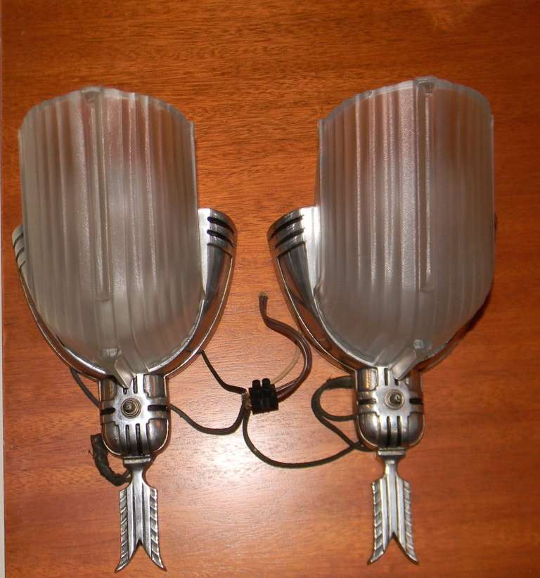 A wonderful pair of streamline Art Deco sconces. These have wonderful lightly frosted faceted glass and were made in America, circa 1930s. One of my favorite designs. The outside metal is aluminum and has been recently polished to a new luster.