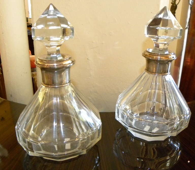 Enjoy this stunning pair of matched heavy crystal decanters.  Both with nice stepped detailing and both with silver-plated collars (each with hallmark).  Very nice condition and very serviceable. There is no damage or repair and these are ready to