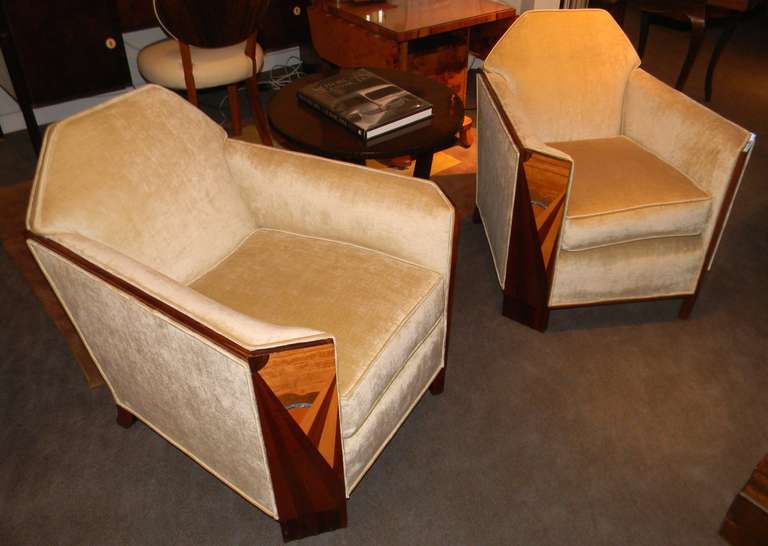 French Club chairs like you've never seen before. The shape is cubist style with the most wonderful wood sunburst marquetry on the front of each panel and fluted foot.  The chairs have just been restored with a Champagne color velour which sets off