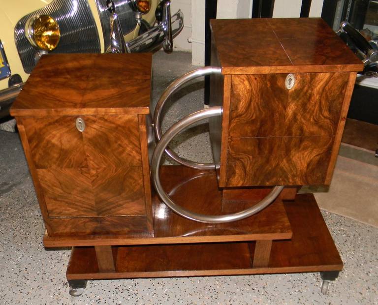 Very unusual bar cart design. This one has two major storage areas that open up to hold bottles, glasses and just about anything. I've never seen this design before. Interesting use of wood and metalwork to create a very fluid artistic design. Nice
