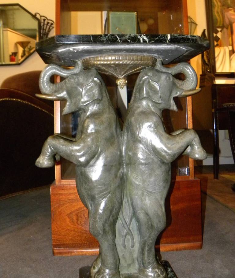 Unusual special French side table, circa 1925.  Two great looking full sized elephants with their trunks pointed upwards (very lucky)! A fun decorative sculpture with artist signature on the bottom P. Seca.  Two pieces of marble, one on the top and