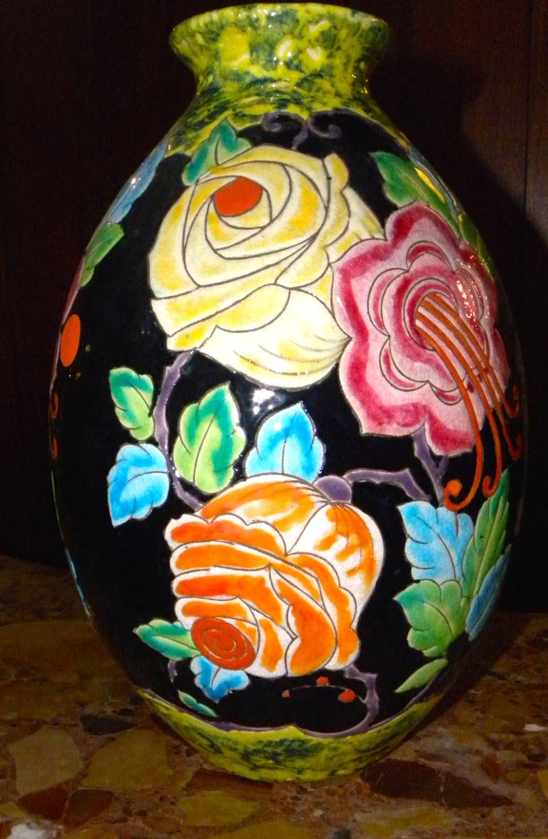 The highly stylized Boch Catteau era vase is executed with the most unusual black background, allowing for the stunning colorful stylized floral arrangement.
The details and perfection of the ceramic cloisonné work is outstanding. Made circa 1930,