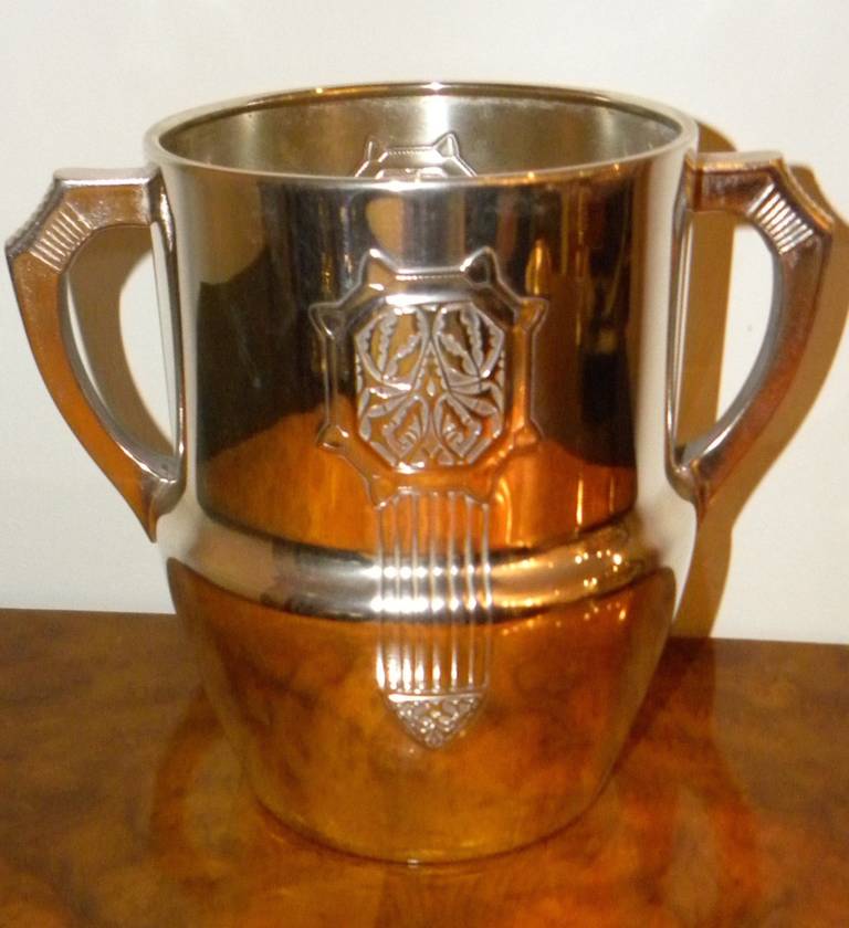 German champagne bucket by famous metal company WMF. Nice details showing Art Nouveau to Art Deco era. Restored condition with unusual shaped handles and stamped floral emblem on two front sides. Getting ready for the next party, this piece will