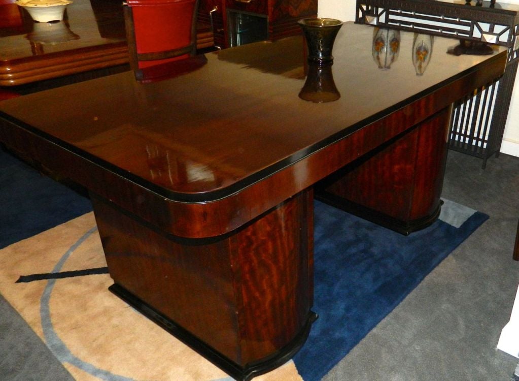 A wonderful and very spectacular Art Deco desk, a Classic modernist piece. Very nice flamed mahogany wood with black lacquer trim detail.
Each bank supports the desk which has three drawers, quite practical for organizing all your stuff. Locks for