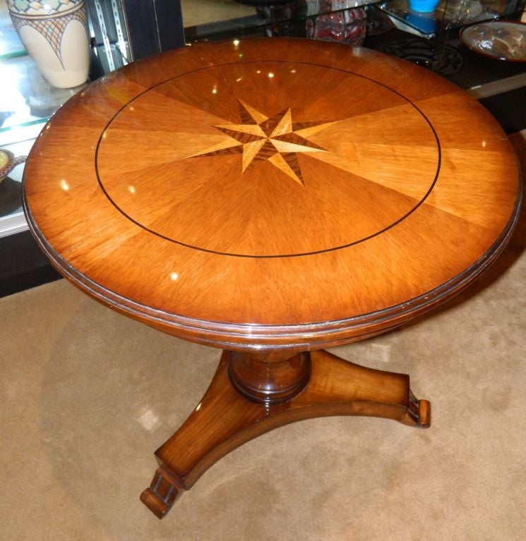 Presented here is a Classic entry style or library table with Classic Regency Art Deco motif. The wood is fantastic and newly restored in a very fine French polish finish. The wood inlay in a modernist geometrical starburst is stunning and very