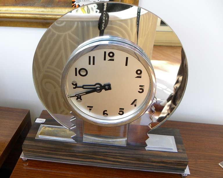 Beautiful simple design in Art Deco style. This wonderful clock has a lot of cool things working (and is in working order). This high quality movement, with key wind is built to last. The clock has a round mirror shape, with zig zag motif and