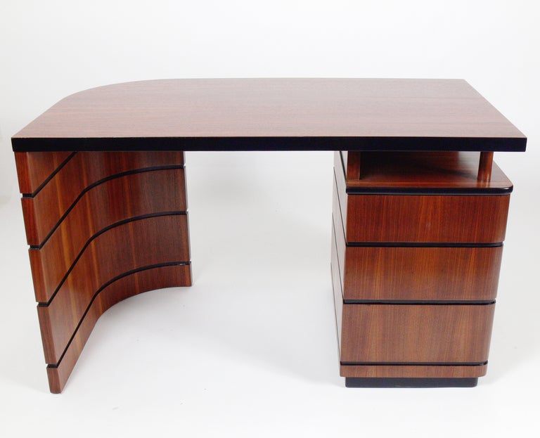 Streamlined Art Deco Desk, attributed to Donald Deskey, American, circa 1930's. Wonderfully grained walnut with black lacquer trim. This piece has been refinished and is ready to use.