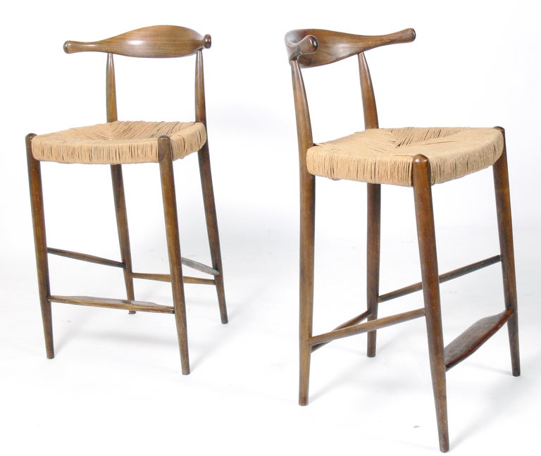 Danish Modern Bar Stools, after a design by Hans Wegner, Danish, circa 1960's. Sculptural teak frames with woven rush seats that lend great visual texture and warmth. The price noted in this listing is for the pair of stools. 

Blanket wrap