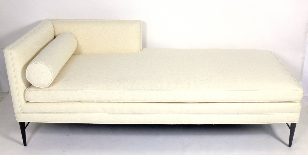 Clean lined modernist daybed by Paul McCobb, American, circa 1950s. It has been completely restored in an ivory color bouclé fabric and the legs have been refinished in an ultra-deep brown lacquer. Brass stretchers hand polished and lacquered.