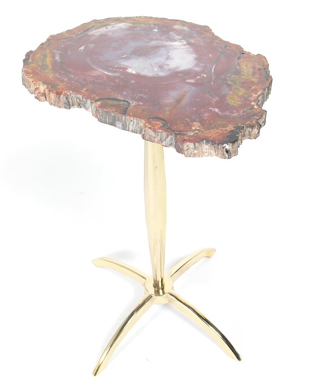 Modernist Petrified Wood and Brass Table, after Philippe Hiquily, unsigned, circa 1960's. Sculptural brass base supports a thick piece of petrified wood, which is thought to be over 200 million years old. The petrified wood top measures 13.5