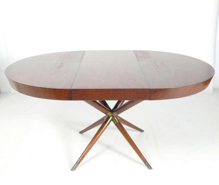 Incredible Italian Dining Table, circa 1950's. This table expands from it's round shape, seating to four to six people, to a large oval to accomodate up to ten guests. With it's three leaves installed it measures an impressive 98