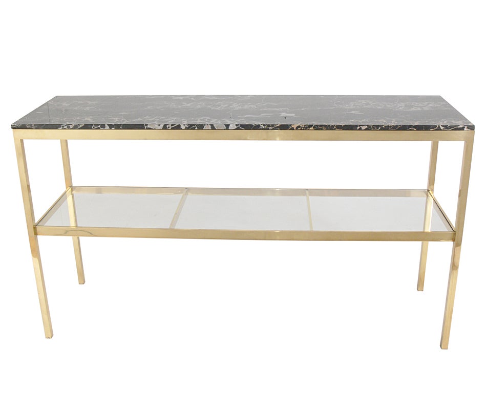 Substantial Brass and Marble Modern Console Table, in the manner of Marc du Plantier, circa 1960's. The beautiful marble top is black with gold, white, and gray veining. The brass has been hand polished and lacquered.