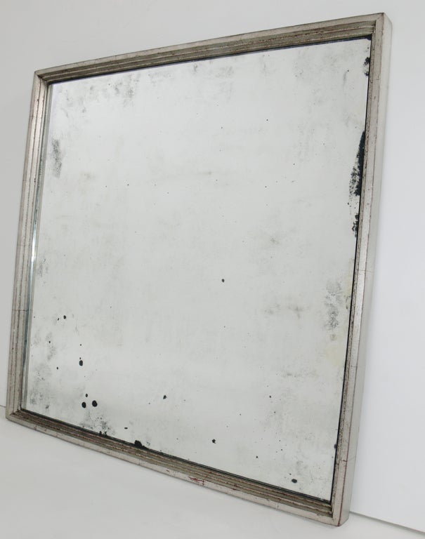 Antiqued Mirror in Graduated Square Silver Leaf Frame, American, circa 1950's. Wonderful patina to both the silver leafed wooden frame and to the mirror. The silvered leafed wooden frame is circa 1950's, and the mirror has been recently antiqued. As