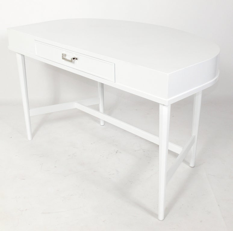 Demilune White Lacquer Desk, American, circa 1950's. This piece is a versatile size and could be used as a desk, console table, or vanity. It has been completely restored in a white lacquer finish and the hardware replated in nickel.