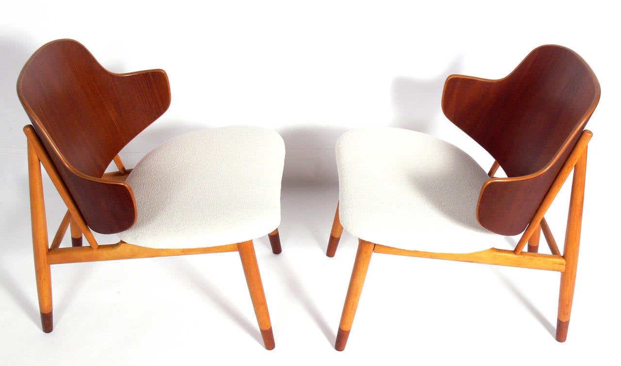 Pair of Danish Modern Lounge Chairs, designed by Ib Kofod-Larsen, Danish, circa 1960's. They have been reupholstered in an ivory color boucle.