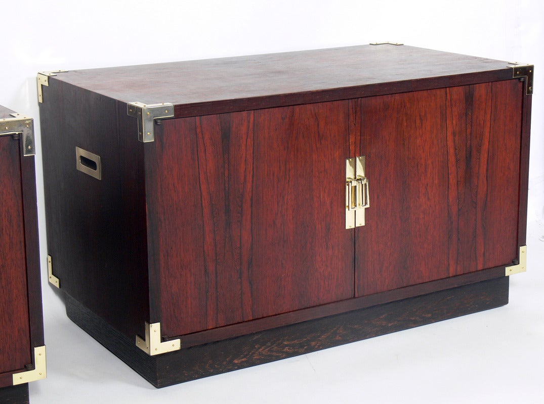 Pair of Rosewood Campaign Chests, circa 1960's. They are a versatile size and can be used as chests or night stands in a bedroom, or as side or end tables in a living area. The brass hardware has been hand polished and lacquered and the chests are