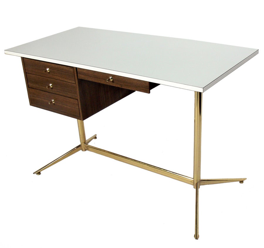 Modernist Desk, designed by Arthur Umanoff, American, circa 1950's. This desk is constructed of sleek laminates, so it is very low maintenance and user friendly. Brass plated metal base and hardware have been hand polished and show some wear.