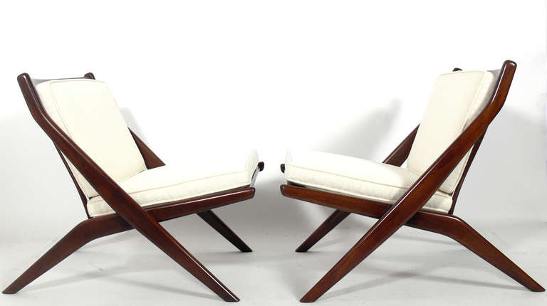 Pair of Scissor Chairs by Folke Ohlsson for Dux, Sweden, circa 1960's.
They have been refinished in a medium brown color and reupholstered in an ivory color boucle fabric.