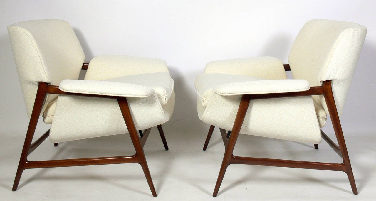 Pair of Danish Modern Lounge Chairs, Denmark, circa 1950s. They have been completely restored with the teak frames refinished and reupholstered in an ivory color bouclé fabric.