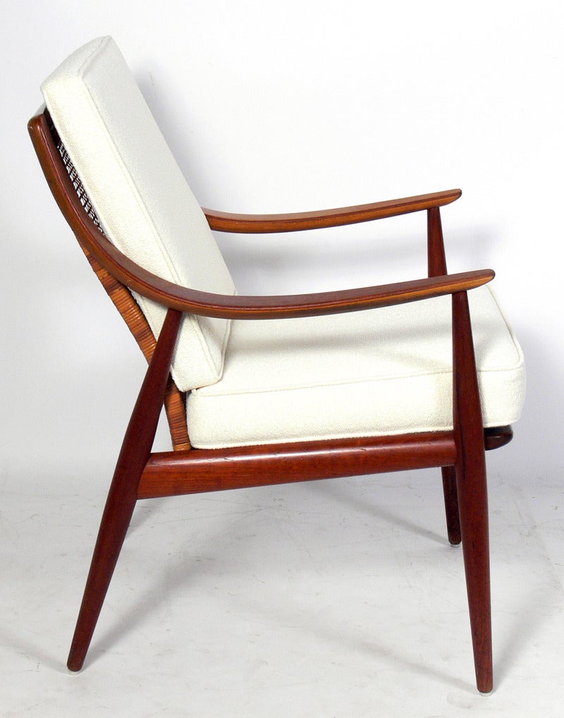 Pair of Danish Modern Lounge Chairs, designed by Peter Hvidt & Orla Molgaard Nielsen for France & Daverkosen, circa 1950's. They retain their original finish and caned backs, both with a warm original patina. Reupholstered in an ivory color boucle