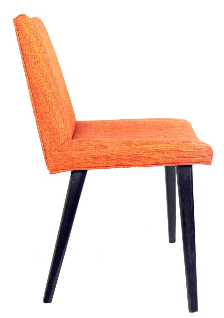 Set of Four Modern Dining Chairs, in the manner of Edward Wormley for Dunbar, American, circa 1950's. This set retains it's original orange upholstery. The legs have been refinished in a dark brown lacquer.
