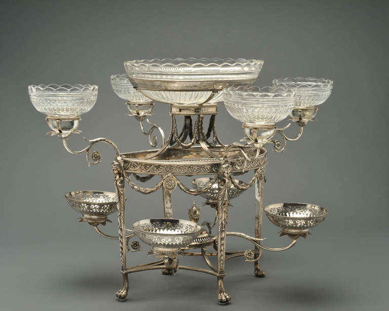 An ornate and finely detailed sterling silver epergne, by Thomas Pitts I, London, 1786. Featuring eight scrolling foliate form arms and one central glass bowl. The lower four arms support pierced openwork sterling bowls, the upper four arms