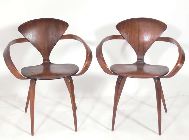 Set of 12 Sculptural Dining Chairs, designed by Norman Cherner for Plycraft, circa 1950's. We currently have 13 of these chairs in stock, 2 arm chairs and 11 side chairs. We get this design fairly often, so if you need more or less of these chairs,