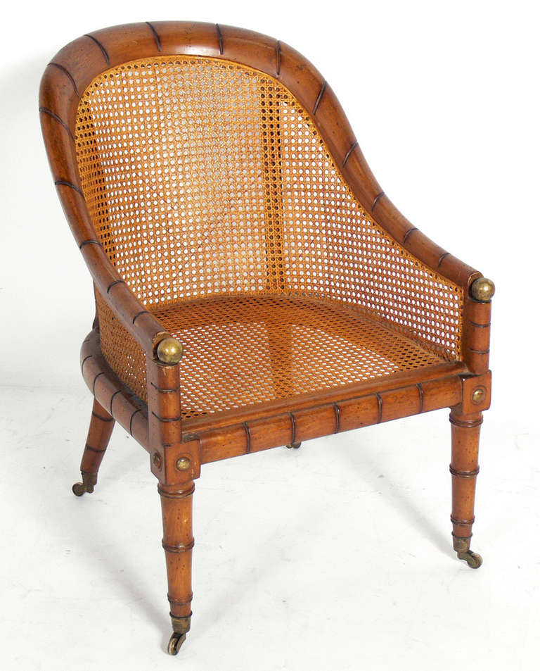 Curvaceous Caned Faux Bamboo Arm Chair with Brass Hardware, probably American, circa 1950's.