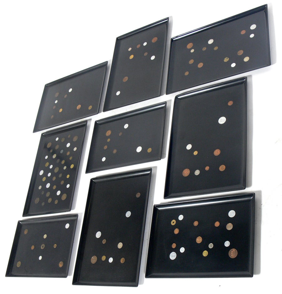 Group of nine coin inlaid trays by The Couroc Company, American, circa 1950's. These would look great mounted on a wall together. Constructed of antique coins mounted in black resin trays.