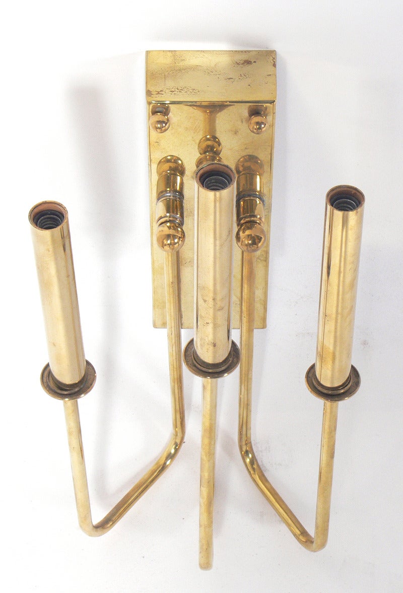 Pair of Brass Three Arm Sconces in the manner of Tommi Parzinger, American, circa 1960's. They are currently being hand polished and lacquered. Rewired and ready to use.