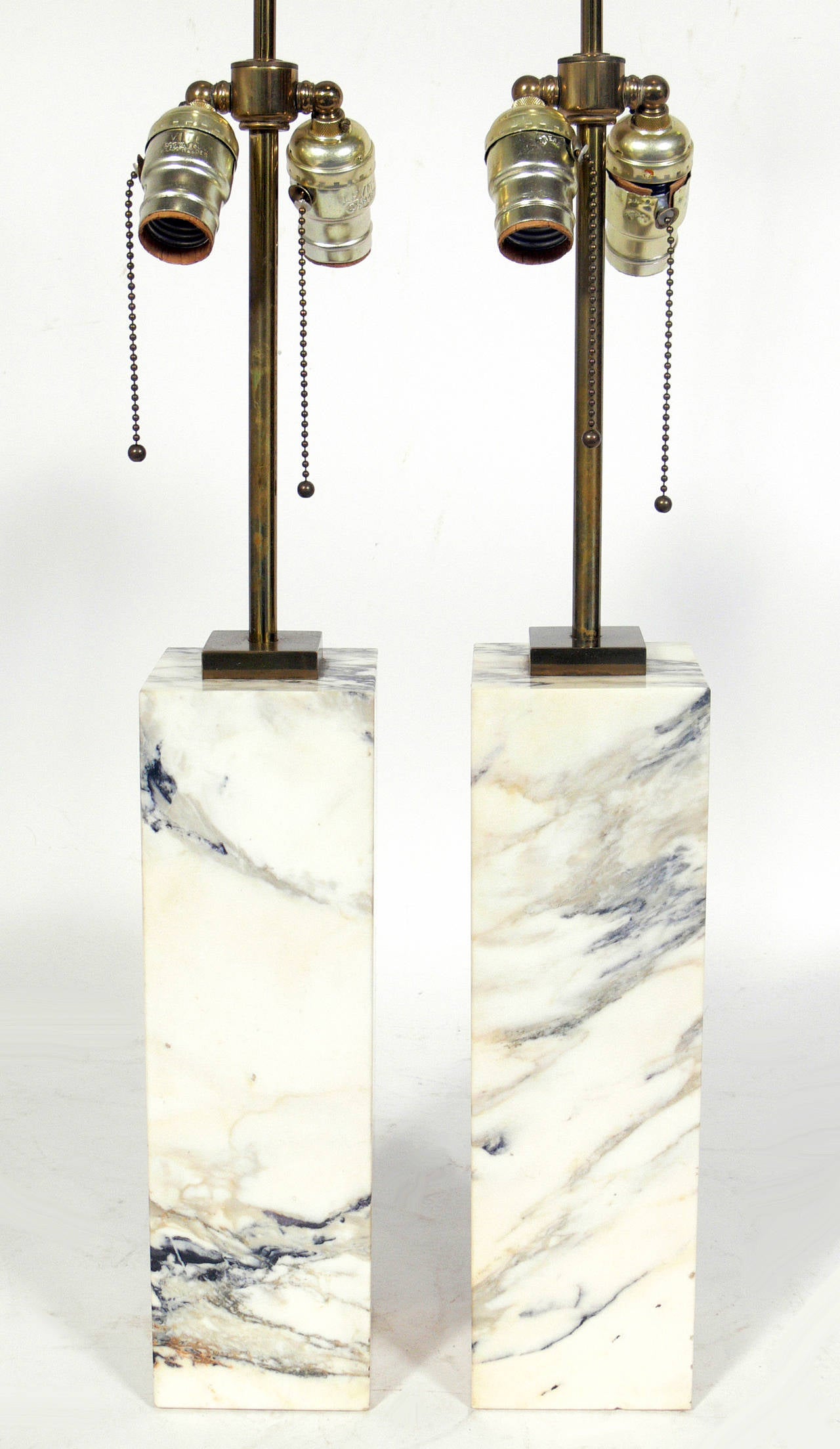 Pair of Marble Lamps designed by T.H. Robsjohn Gibbings for Hansen, circa 1950's. Clean lined architectural design in an ivory colored marble with gray, tan, and black veining. Brass hardware retains warm original patina. If you prefer, we can