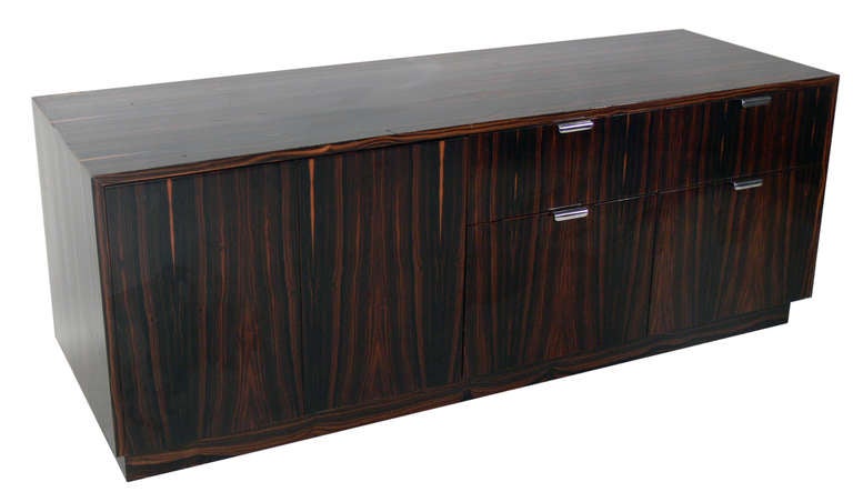 Custom Macassar Ebony Wood Credenza, American, circa 1980's. Custom made in expressively grained macassar ebony wood with chrome plated metal hardware. This is a versatile piece and can be used as a credenza, bar, dresser, or cabinet. It is a low