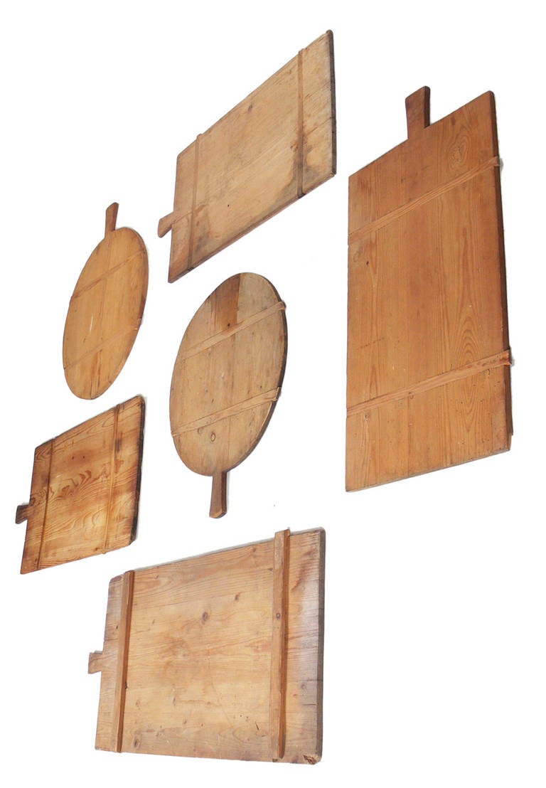 Collection of Antique Wood Cutting or Serving Boards, probably American, circa late 19th - early 20th century. They would make a great wall sculpture, mounted as a group in a kitchen or dining area. They retain their warm original patina. The