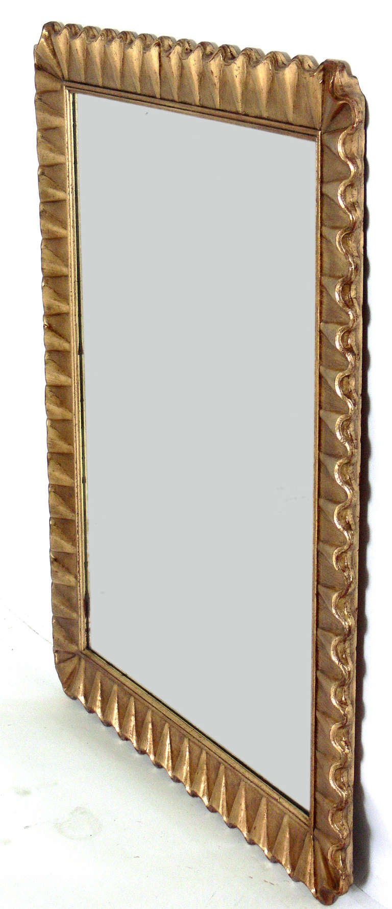 Gold Leaf Scalloped Mirror, American, circa 1940's. Elegant undulating form. Retains wonderful patina to both the gold leafed frame and the original mirrored glass. Executed in gold leafed plaster and wood.