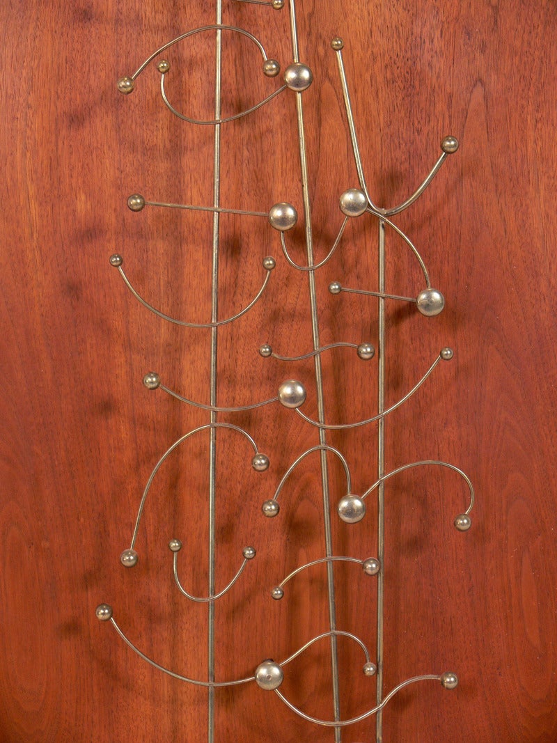 Abstract wire wall sculpture on walnut mount, American, circa 1950s.