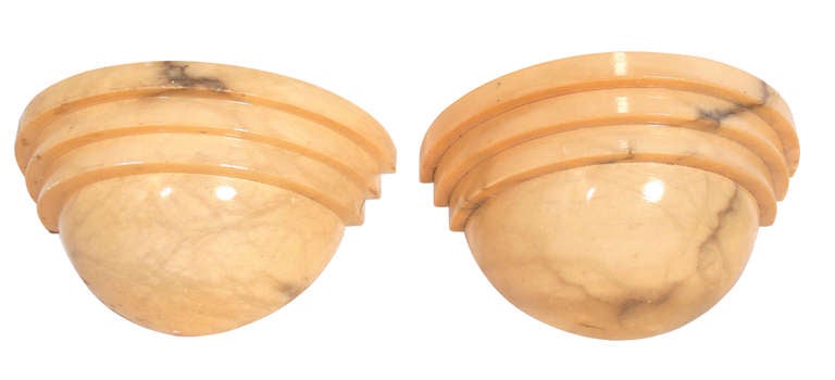 Pair of alabaster sconces, circa 1970's. They emit a wonderful glow when lit, showing the graining of the beautiful alabaster. We have two pairs of these sconces available. The price noted below is for one pair of sconces.