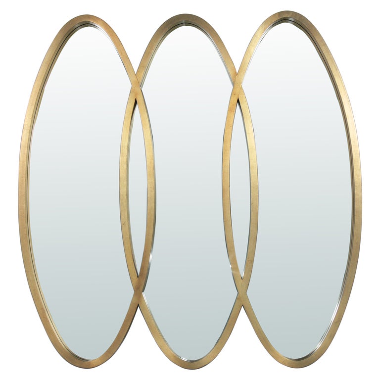 Modernist Oval Gold Leaf Triple Mirror, American, circa 1960's. It exhibits wonderful patina and wear to the gold leafing, beautifully exposing a bit of the Chinese Red bole or underlayer. This mirror has a sculptural form and would fit seamlessly