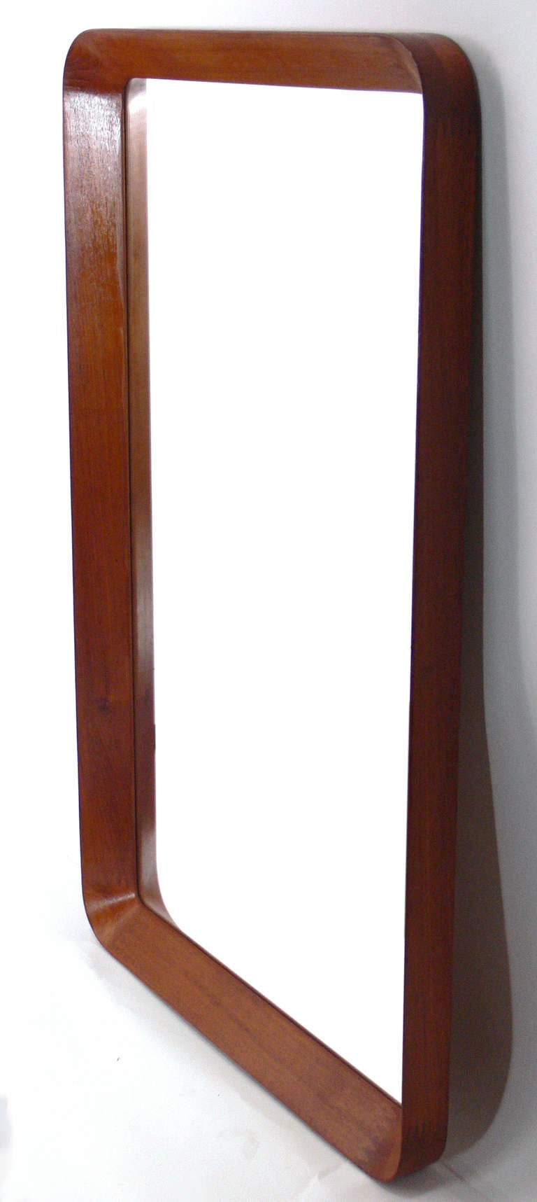 Danish Modern teak wall mirror, designed for the Pedersen & Hansen Company, Denmark, circa 1960's. Simple, clean lined design with an interesting profile and great attention to detail, like the finger joinery at the corners.
