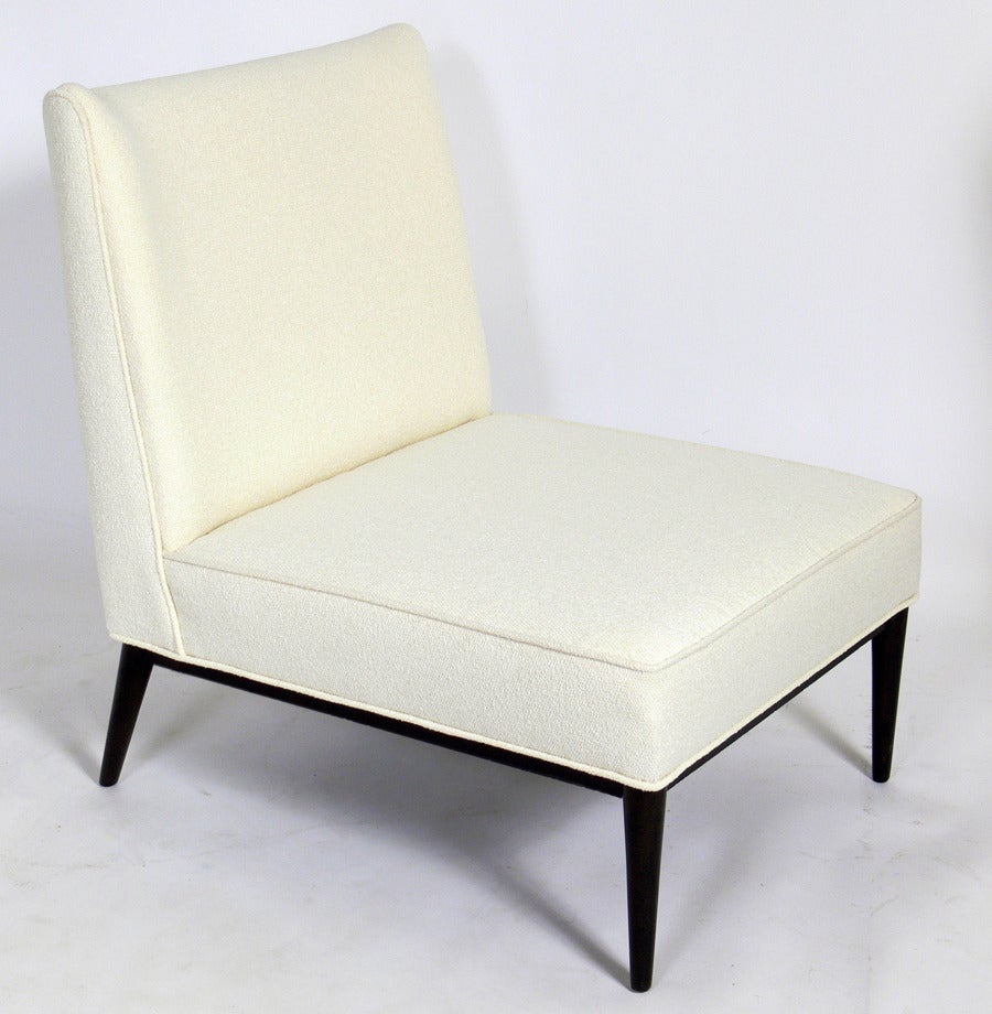 Low Slung Modern Slipper Chair by Paul McCobb, American, circa 1950's.
It has been completely restored in an ivory color boucle upholstery and the base finished in an ultra-deep brown lacquer.