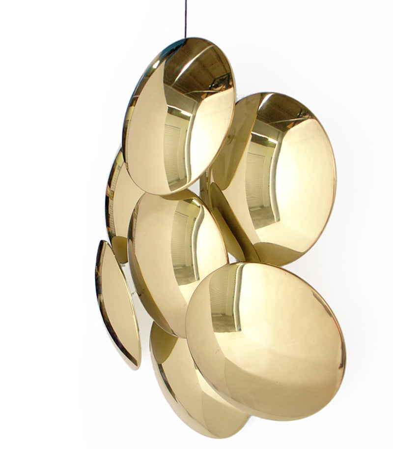 Large scale, sculptural brass wall sconce or applique, designed by Reggiani, circa 1970's. Wonderful mood lighting is emitted from the backlit discs, which cast sculptural shadows. This sconce is mounted with a standard threaded electrical box.