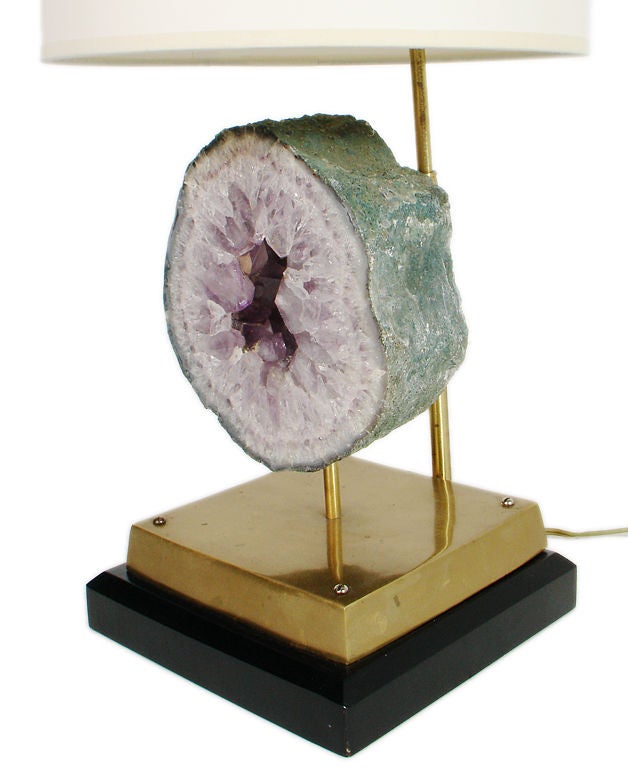 Sculptural Amethyst Specimen Lamp, circa 1960's. A thick amethyst geode slice is surmounted upon a brass and black lacquered base. The lamp measures 24