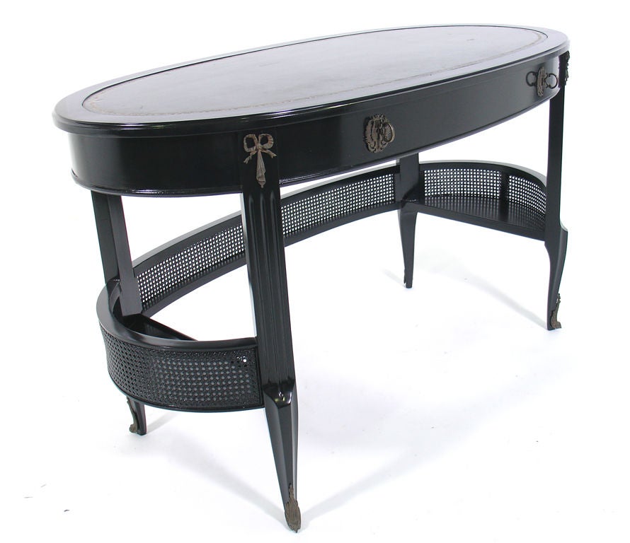 Elegant Black Lacquer Oval Desk with Bronze Hardware, probably American, circa 1940's. It is constructed of black lacquered wood with a deep green leather top, and bronze hardware. This piece is a versatile size and could be used as a desk or